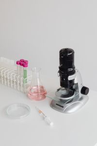 Kaboompics - Pink-Capped Sample Tubes and Microscope on White Background