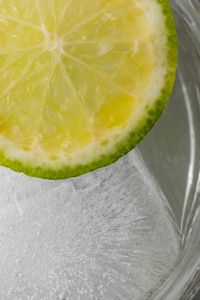 Kaboompics - Lime Wheel Resting on a Large Ice Cube Inside a Glass, Extreme Citrus Water Macro