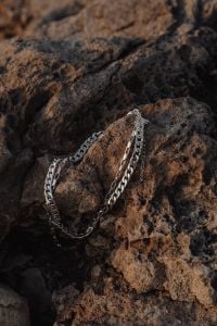 Kaboompics - Silver Chain Necklace on Dark Porous Volcanic Rock