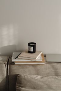 Kaboompics - Home Office Copy Space with Laptop, Books and Black Candle on Sofa
