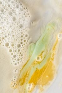 Kaboompics - Sage and Gold Skincare Cream Swirls with Bubbles Along the Left Edge