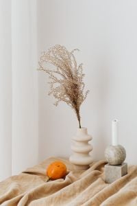 Kaboompics - Dried Florals and Stone Candleholder Styled with Orange Fruit in a Neutral Interior