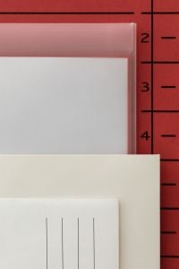 Kaboompics - Layered Blank Paper and Translucent File Folder on Red Background
