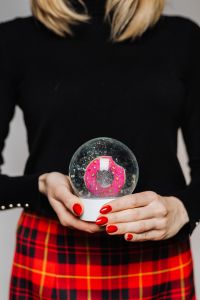 Kaboompics - Woman Holding a Clear Snow Globe with Pink Center, Black Sweater and Red Plaid Skirt