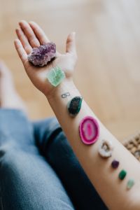 Kaboompics - Woman’s Open Palm with Amethyst and Green Crystals, Infinity Wrist Tattoo Close-Up