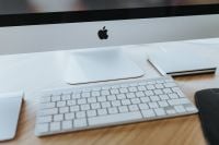 Kaboompics - Apple iMac Monitor and White Keyboard on a Light Wood Desk, Minimal Office Setup