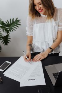 Kaboompics - Female Professional Signing Contract on Black Desk
