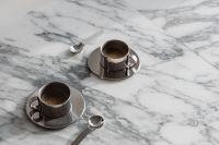 Kaboompics - Two Chrome Espresso Cups on Saucers with Spoons, Wide Arabescato Marble Coffee Flat Lay