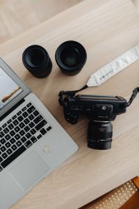 Kaboompics - Two Camera Lenses Beside a Laptop on a Light Wood Desk, Photographer Workspace Still Life