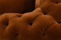 Kaboompics - Plush Orange Velvet Sofa Cushions with Deep Button Tufting