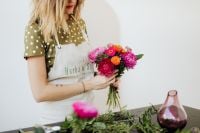 Kaboompics - Woman Holding a Colorful Bouquet Beside a Floral Worktable