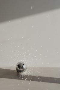 Kaboompics - Minimal Disco Ball at the Bottom of a Neutral Wall with Party Light Reflections