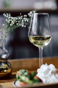 Kaboompics - Strawberries with cream and glass of white wine on wooden tray
