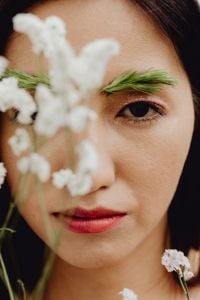 Kaboompics - Vertical Beauty Close-Up with Greenery Eyebrow Styling and Soft White Flower Foreground