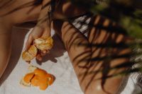 Kaboompics - Partly Peeled Orange Held over a Textured Beach Towel