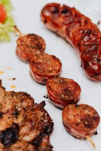 Kaboompics - Macro of Grilled Sausage Medallions and Whole Sausage beside Pork Neck Steak