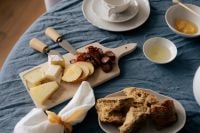 Kaboompics - Cheese Board Bread and White Teapot on Blue Linen