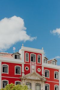 Kaboompics - Red and White Historic Facade with Pediment Beneath Blue Lisbon Sky
