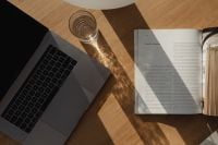 Kaboompics - Laptop and Open Magazine with Window Shadows on Wooden Table