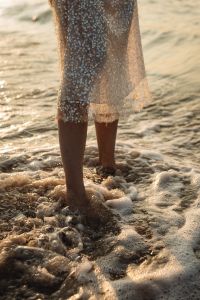 Kaboompics - Barefoot Woman Walking in Shallow Waves in Sequin Dress