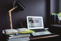 Kaboompics - Laptop, Desk Lamp and Stacked Books in Dark Office