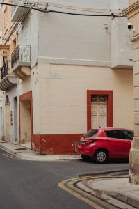 Kaboompics - Red Car Outside a Malta Townhouse