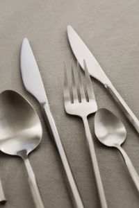 Kaboompics - Modern Steel Knives and Forks with Spoon on Textured Neutral Background