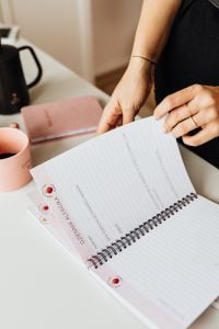 Kaboompics - Close-Up of Hands Flipping a Daily Planner with Coffee Nearby