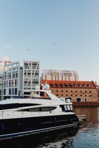 Kaboompics - Vertical Gdańsk Marina View with Luxury Yacht, Brick Warehouse and Modern Waterfront Architecture