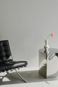 Kaboompics - Black Leather Lounge Chair Beside Chrome Pedestal and White Vase