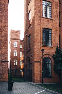 Kaboompics - Narrow Brick Courtyard with Arched Windows and a Black Lamp