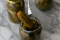 Kaboompics - Fork Lifting a Pickle from an Open Glass Jar, Moody Kitchen Close-Up