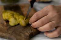 Kaboompics - Slicing Pickles on a Wooden Cutting Board, Close-Up Kitchen Prep