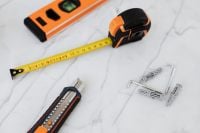 Kaboompics - Close-Up DIY Tool Set with Orange Spirit Level, Measuring Tape, Utility Knife and Wall Anchors