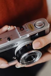 Kaboompics - Macro View of Olympus Trip 35 Controls and Lens Against Rust Fabric