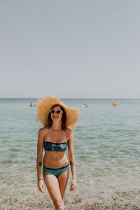 Kaboompics - Smiling Woman in White Sunglasses and Raffia Hat in Shallow Water