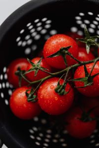 Kaboompics - Close-Up Cherry Tomatoes Framed by Black Colander Holes