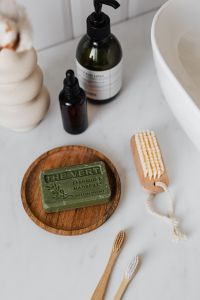 Kaboompics - Amber Dropper and Green Glass Pump Bottles Beside a White Sink, Minimal Bathroom Beauty Styling
