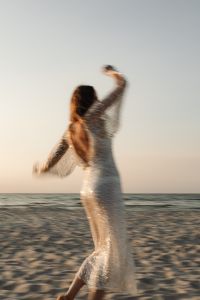 Kaboompics - Motion Blur Woman Twirling in Sequin Dress on Beach