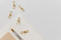 Kaboompics - Silver Fountain Pen Nib and Gold Paper Clips on Diagonal Lined Notebook with Wide Copy Space