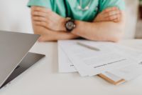 Kaboompics - Close-Up of Folded Arms and Medical Papers