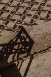 Kaboompics - Geometric Patterned Tile Floor with Decorative Ironwork Shadow