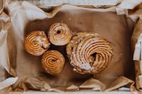 Kaboompics - Four Polish Pączki Donuts Arranged in Brown Paper for Fat Thursday