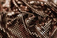 Kaboompics - Warm Bronze Mesh Sequin Fabric Crossing in Overlapping Folds, Abstract Background