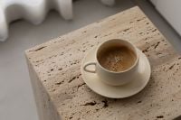Kaboompics - Cream Coffee Cup on Travertine Side Table in Soft Light