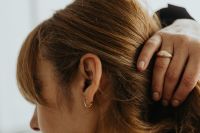 Kaboompics - Woman Touching Hair to Show Gold Hoop Earring and Rings
