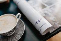 Kaboompics - Coffee Cup and Rolled Magazine on a Dark Desk