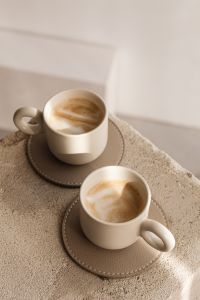 Kaboompics - Latte Mugs on a Stone Pedestal with Geometric Window Shadows