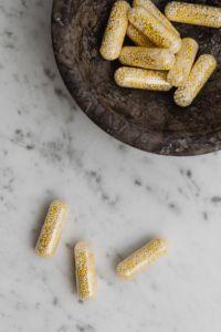 Kaboompics - Bead-Filled Capsules in a Dark Bowl with Marble Background