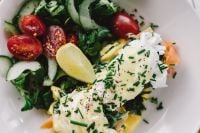 Kaboompics - Close up image of young woman eating classic breakfast at restaurant